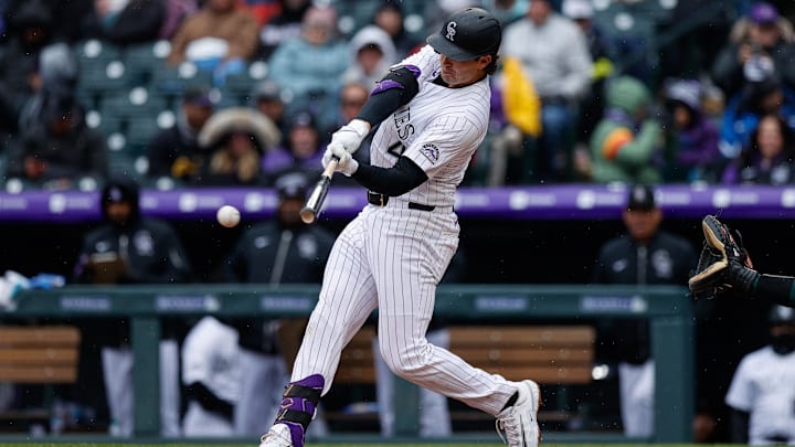 Apr 4, 2025; Denver, Colorado, USA; Colorado Rockies first baseman Michael Toglia (4) hits a single in the fourth inning against the Athletics at Coors Field. Mandatory Credit: Isaiah J. Downing-Imagn Images