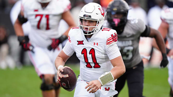 Nov 16, 2024; Boulder, Colorado, USA; Utah Utes quarterback Isaac Wilson (11) scrambles with the ball in the second half against the Colorado Buffaloes at Folsom Field. Mandatory Credit: Ron Chenoy-Imagn Images