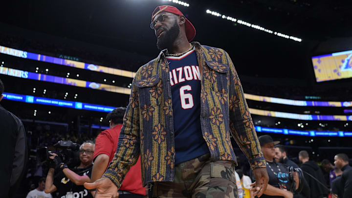 Oct 24, 2025; Los Angeles, California, USA; Los Angeles Lakers forward LeBron James poses in the Arizona Wildcats jersey of his son Bryce James (6) during the game against the Minnesota Timberwolves at Crypto.com Arena. Mandatory Credit: Kirby Lee-Imagn Images