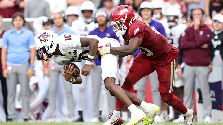 Oct 18, 2025; Fayetteville, Arkansas, USA; Texas A&M Aggies quarterback Marcel Reed (10) is tackled for a loss by Arkansas Razorbacks linebacker Xavian Storey Jr (10) during the second quarter at Donald W. Reynolds Razorback Stadium. Mandatory Credit: Nelson Chenault-Imagn Images