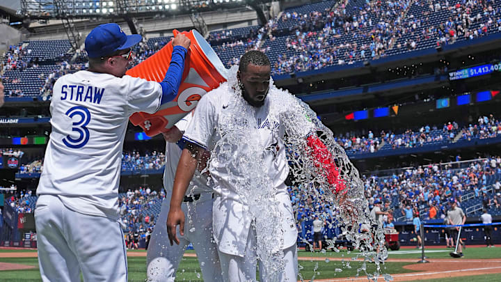 Jul 20, 2025; Toronto, Ontario, CAN; Toronto Blue Jays first baseman Vladimir Guerrero Jr. (27) gets the water bucket poured on him at the end of the ninth inning against the San Francisco Giants at Rogers Centre. 