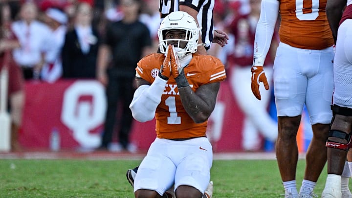 Texas Longhorns defensive end Colin Simmons kneels on the field after the Longhorns stop the Oklahoma Sooners during the second half at the Cotton Bowl.