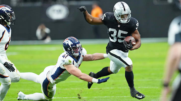 Jan 7, 2024; Paradise, Nevada, USA; Las Vegas Raiders running back Zamir White (35) is pushed out of bounds by Denver Broncos linebacker Drew Sanders (41) during the second quarter at Allegiant Stadium. Mandatory Credit: Stephen R. Sylvanie-USA TODAY Sports