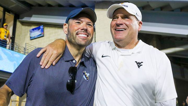 Sep 13, 2025; Morgantown, West Virginia, USA; West Virginia Mountaineers head coach Rich Rodriguez celebrates with West Virginia University athletic director Wren Baker after defeating the Pittsburgh Panthers at Milan Puskar Stadium. Mandatory Credit: Ben Queen-Imagn Images Sep 13, 2025; Morgantown, West Virginia, USA; West Virginia Mountaineers head coach Rich Rodriguez celebrates with West Virginia University athletic director Wren Baker after defeating the Pittsburgh Panthers at Milan Puskar Stadium. Mandatory Credit: Ben Queen-Imagn Images