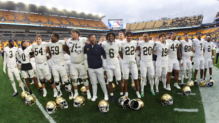 Nov 15, 2025; Pittsburgh, Pennsylvania, USA; Notre Dame Fighting Irish head coach Marcus Freeman (middle) joins his players in singing the victory song after defeating the Pittsburgh Panthers at Acrisure Stadium. Mandatory Credit: Charles LeClaire-Imagn Images Nov 15, 2025; Pittsburgh, Pennsylvania, USA; Notre Dame Fighting Irish head coach Marcus Freeman (middle) joins his players in singing the victory song after defeating the Pittsburgh Panthers at Acrisure Stadium. Mandatory Credit: Charles LeClaire-Imagn Images