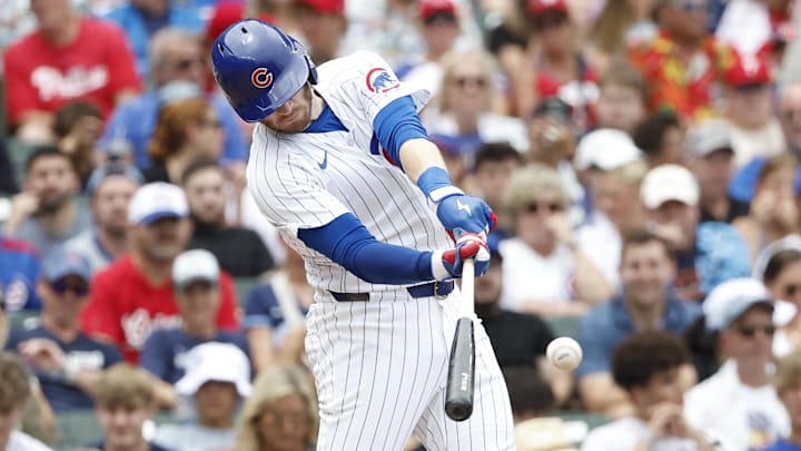 Jul 4, 2024; Chicago, Illinois, USA; Chicago Cubs outfielder Ian Happ (8) singles against the Philadelphia Phillies during the second inning at Wrigley Field.