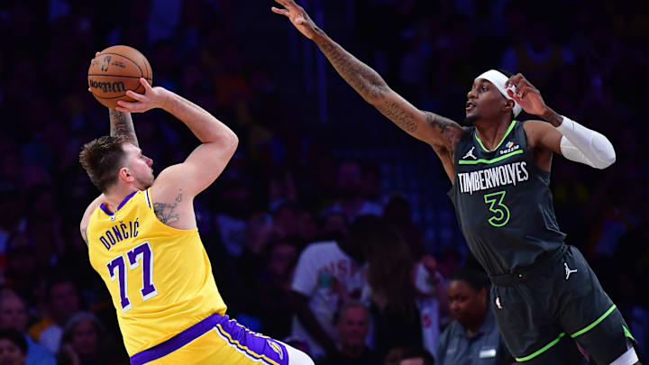 Apr 30, 2025; Los Angeles, California, USA; Los Angeles Lakers guard Luka Doncic (77) shoots against Minnesota Timberwolves forward Jaden McDaniels (3) during the second half in game five of first round for the 2025 NBA Playoffs at Crypto.com Arena. Mandatory Credit: Gary A. Vasquez-Imagn Images