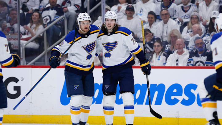 Apr 19, 2025; Winnipeg, Manitoba, CAN; St. Louis Blues forward Oskar Sundqvist (70) is congratulated by teammates on his goal against the Winnipeg Jets during the first period in game one of the first round of the 2025 Stanley Cup Playoffs at Canada Life Centre. Mandatory Credit: Terrence Lee-Imagn Images