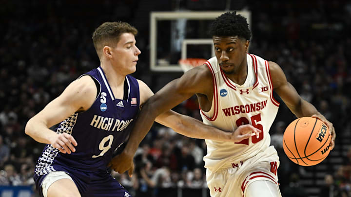 Mar 19, 2026; Portland, OR, USA; Wisconsin Badgers guard John Blackwell (25) drives against High Point Panthers guard Conrad Martinez (9) during the second half of a first round game of the men's 2026 NCAA Tournament at Moda Center. 