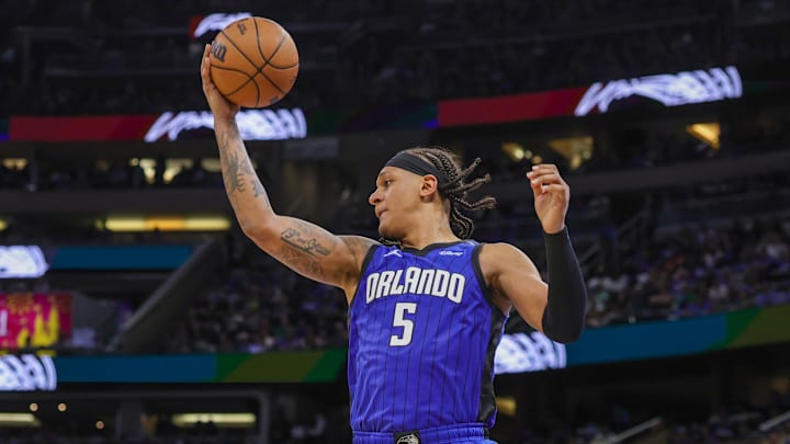 Apr 25, 2025; Orlando, Florida, USA; Orlando Magic forward Paolo Banchero (5) grabs the rebound against the Boston Celtics during the second half of game three of first round for the 2024 NBA Playoffs at Kia Center. Mandatory Credit: Mike Watters-Imagn Images