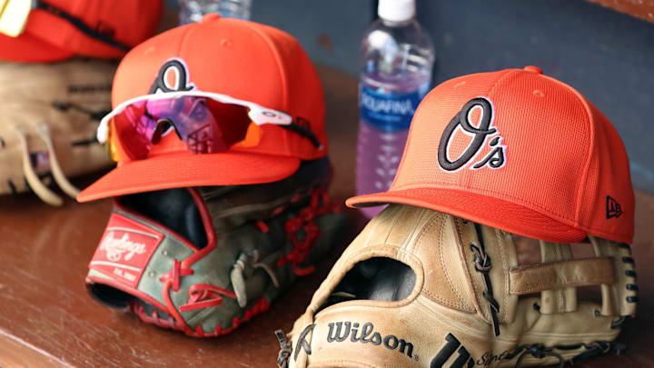 Mar 11, 2024; Tampa, Florida, USA;  A detailed view of Baltimore Orioles baseball hats and gloves in the dugout during the first inning against the New York Yankees at George M. Steinbrenner Field. Mandatory Credit: Kim Klement Neitzel-Imagn Images