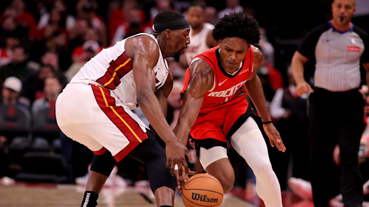 Dec 29, 2024; Houston, Texas, USA; Miami Heat guard Dru Smith (12) and Houston Rockets guard Amen Thompson (1) pursue a loose ball during the second quarter at Toyota Center. Mandatory Credit: Erik Williams-Imagn Images
