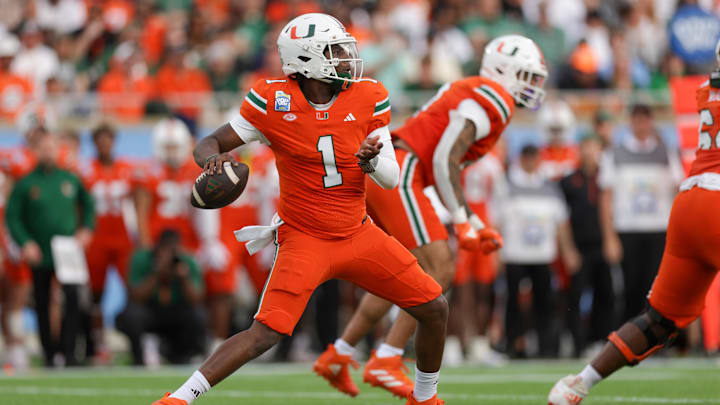Dec 28, 2024; Orlando, FL, USA; Miami Hurricanes quarterback Cam Ward (1) drops back to pass against the Iowa State Cyclones in the first quarter during the Pop Tarts Bowl at Camping World Stadium.  