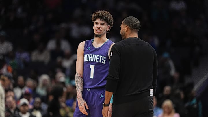 Mar 20, 2025; Charlotte, North Carolina, USA; Charlotte Hornets guard LaMelo Ball (1) talks with head coach Charles Lee  during a  free throw during the second half against the New York Knicks at Spectrum Center. Mandatory Credit: Jim Dedmon-Imagn Images