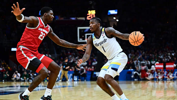 Mar 21, 2025; Cleveland, OH, USA;  Marquette Golden Eagles guard Kam Jones (1) dribbles the ball defended by New Mexico Lobos center Nelly Junior Joseph (23) in the second half during the NCAA Tournament First Round at Rocket Arena. Mandatory Credit: Ken Blaze-Imagn Images