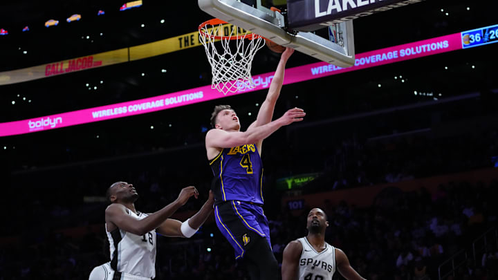 Mar 17, 2025; Los Angeles, California, USA; Los Angeles Lakers guard Dalton Knecht (4) shoots the ball against San Antonio Spurs center Bismack Biyombo (18) and forward Harrison Barnes (40) in the first half at Crypto.com Arena. Mandatory Credit: Kirby Lee-Imagn Images
