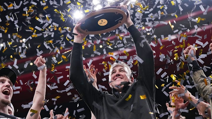 Purdue Boilermakers head coach Matt Painter holds up the NCAA midwest regionals trophy 