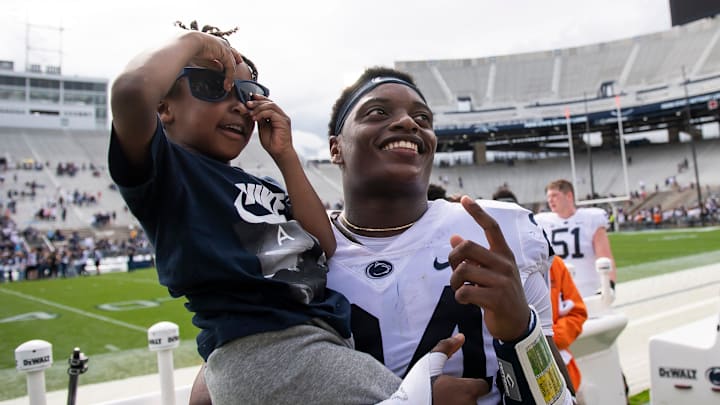 Penn State freshman Ta'Mere Robinson poses for a photo with a young fan following the Blue-White game at Beaver Stadium on Saturday, April 15, 2023, in State College.