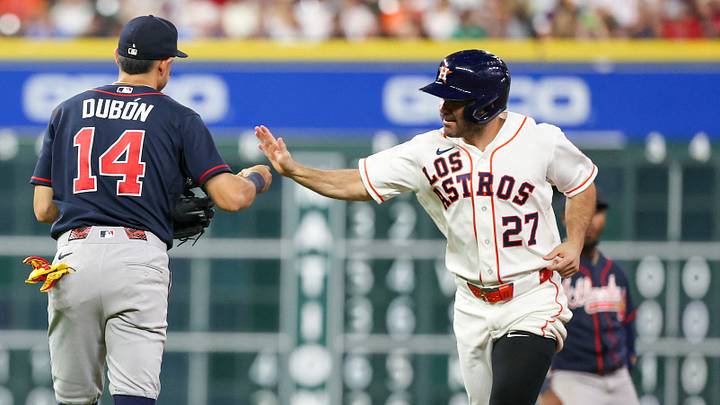 Atlanta Braves shortstop Mauricio Dubon (14) high-fives Houston Astros second baseman Jose Altuve (27) after Altuve was forced out and headed back to his dugout.  Credit: Thomas Shea-Imagn Images