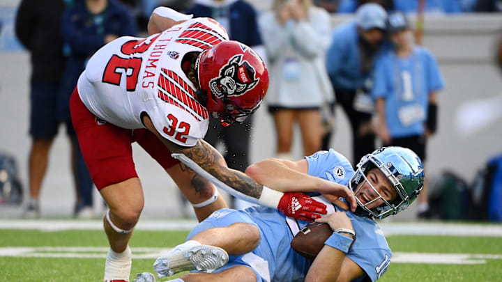 Nov 25, 2022; Chapel Hill, North Carolina, USA; North Carolina State Wolfpack linebacker Drake Thomas (32) sacks North Carolina Tar Heels quarterback Drake Maye (10) in the first quarter at Kenan Memorial Stadium. Mandatory Credit: Bob Donnan-Imagn Images Nov 25, 2022; Chapel Hill, North Carolina, USA; North Carolina State Wolfpack linebacker Drake Thomas (32) sacks North Carolina Tar Heels quarterback Drake Maye (10) in the first quarter at Kenan Memorial Stadium. Mandatory Credit: Bob Donnan-Imagn Images