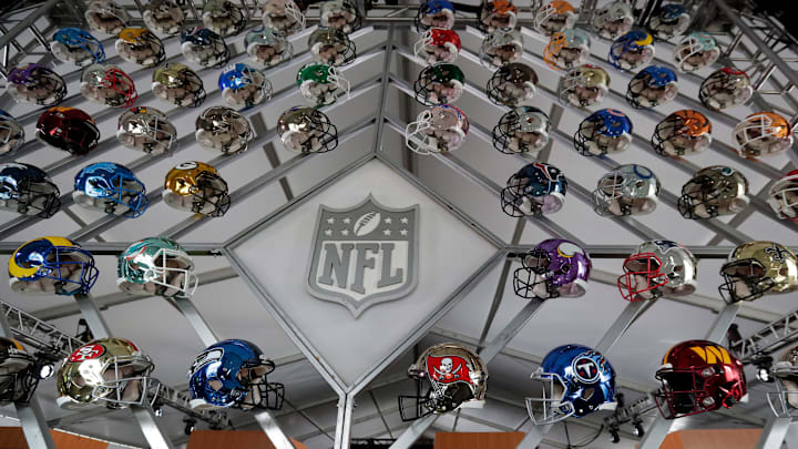 A wall of team helmets on display in the gallery tent on the 2025 NFL Draft campus in the Green Bay Packers' Titletown District on April 21, 2025, in Aswaubenon, Wis.