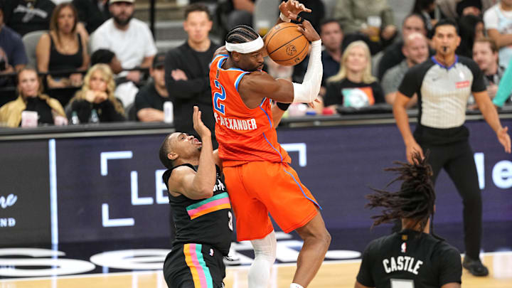 Dec 23, 2025; San Antonio, Texas, USA; Oklahoma City Thunder guard Shai Gilgeous-Alexander (2) grabs a rebound over San Antonio Spurs forward Keldon Johnson (3) during the first half at Frost Bank Center. Mandatory Credit: Scott Wachter-Imagn Images
