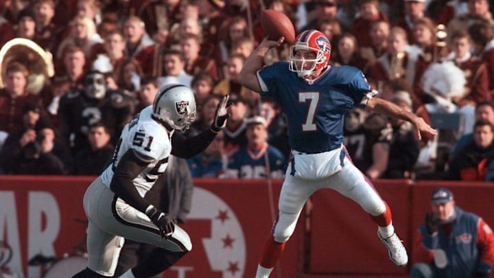 Buffalo Bills QB Doug Flutie leaps high to get a pass over Raiders LB Lance Johnstone.