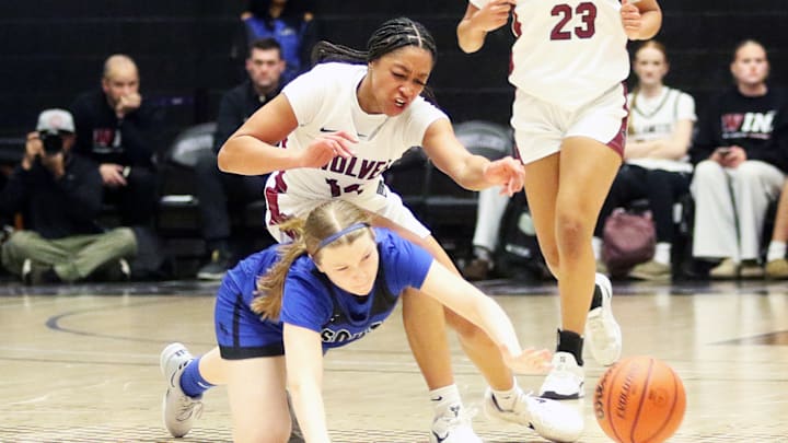 Tualatin junior Maaya Lucas tumbles over South Medford sophomore Payton Andersen as they go after a loose ball during Wednesday’s Class 6A state tournament game.