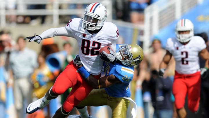 Oct 30, 2010; Pasadena, CA, USA; Arizona Wildcats wide receiver Juron Criner (82) gets tacked by UCLA Bruins corner back Andrew Abott during the game at the Rose Bowl. Mandatory Credit: Kelvin Kuo-Imagn Images Oct 30, 2010; Pasadena, CA, USA; Arizona Wildcats wide receiver Juron Criner (82) gets tacked by UCLA Bruins corner back Andrew Abott during the game at the Rose Bowl. Mandatory Credit: Kelvin Kuo-Imagn Images