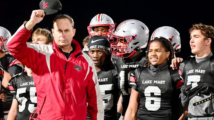 Lake Mary coach Scott Perry (left) tips his hat to the fans with his players around him following the Rams’ 42-3 win against Seminole on Friday night. His Rams are ranked No. 4 in this week's Top 25 Central Florida High School Football Rankings.