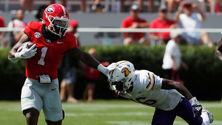 Georgia running back Trevor Etienne (1) stiff-arms Tennessee Tech defensive back Omari Philyaw (16) during the first half of a NCAA college football game in Athens, Ga., on Saturday, Sept. 7, 2024.