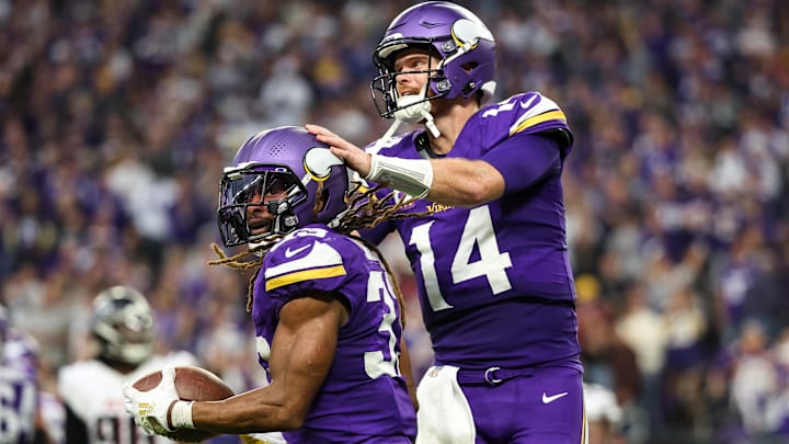 Minnesota Vikings running back Aaron Jones celebrates his rushing touchdown with quarterback Sam Darnold (14) during the fourth quarter against the Atlanta Falcons at U.S. Bank Stadium in Minneapolis on Dec. 8, 2024. 