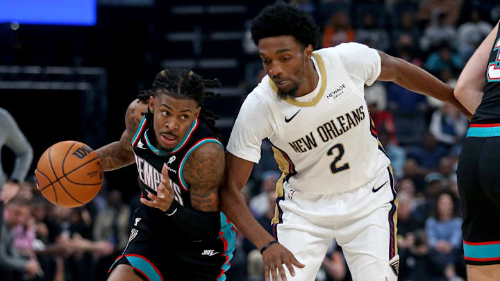 Oct 22, 2025; Memphis, Tennessee, USA; Memphis Grizzlies guard Ja Morant (12) dribbles as New Orleans Pelicans forward Herbert Jones (2) defends during the first quarter at FedExForum. Mandatory Credit: Petre Thomas-Imagn Images