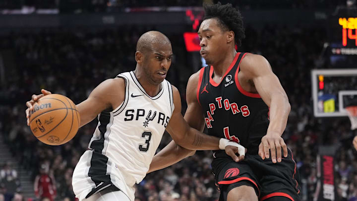 Mar 23, 2025; Toronto, Ontario, CAN; San Antonio Spurs guard Chris Paul (3) drives to the net against Toronto Raptors guard Scottie Barnes (4) during the second half at Scotiabank Arena. Mandatory Credit: John E. Sokolowski-Imagn Images