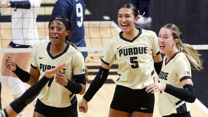 Purdue Boilermakers middle blocker Raven Colvin, setter Taylor Anderson, and outside hitter Kenna Wollard celebrate 