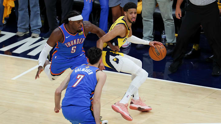 Jun 19, 2025; Indianapolis, Indiana, USA; Indiana Pacers guard Tyrese Haliburton (0) dribbles the ball defended by Oklahoma City Thunder guard Luguentz Dort (5) and forward Chet Holmgren (7) in the second quarter during game six of the 2025 NBA Finals at Gainbridge Fieldhouse. Mandatory Credit: Trevor Ruszkowski-Imagn Images