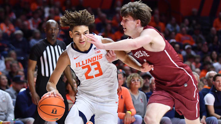 Nov 14, 2025; Champaign, Illinois, USA;  Illinois Fighting Illini guard Keaton Wagler (23) drives the ball against Colgate Raiders guard Ben Tweedy (6) during the first half at State Farm Center. Mandatory Credit: Ron Johnson-Imagn Images