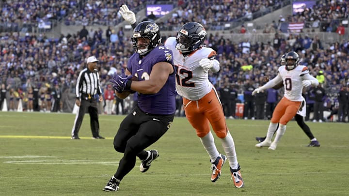 Nov 3, 2024; Baltimore, Maryland, USA; Baltimore Ravens running back Justice Hill (43) runs for a touchdown as Denver Broncos linebacker Kwon Alexander (12) defends during the second half at M&T Bank Stadium. Nov 3, 2024; Baltimore, Maryland, USA; Baltimore Ravens running back Justice Hill (43) runs for a touchdown as Denver Broncos linebacker Kwon Alexander (12) defends during the second half at M&T Bank Stadium.