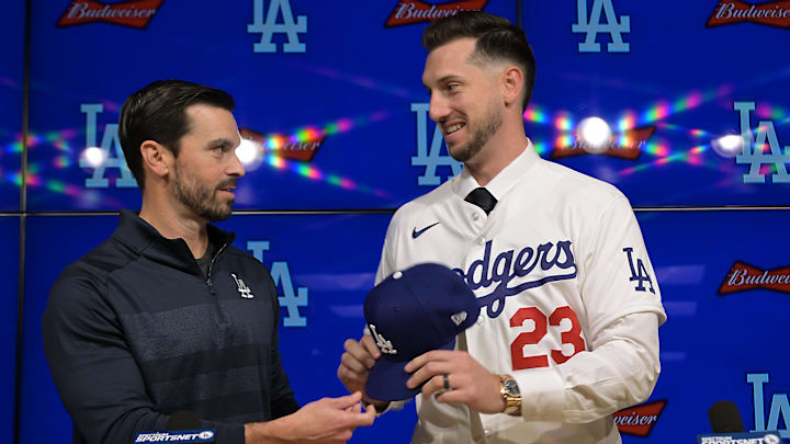 Jan 21, 2026; Los Angeles, CA, USA;  Los Angeles Dodgers general manager Brandon Gomes hands fielder Kyle Tucker (23) his jersey and cap as he is introduced to the media during a press conference at Dodger Stadium. Mandatory Credit: Jayne Kamin-Oncea-Imagn Images