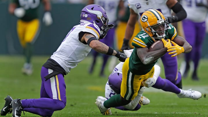 Green Bay Packers wide receiver Jayden Reed (11) lunges for a first down against Minnesota Vikings cornerback Byron Murphy Jr. (7) and safety Camryn Bynum (24) during their football game Sunday, October 29, 2023, at Lambeau Field in Green Bay, Wis.