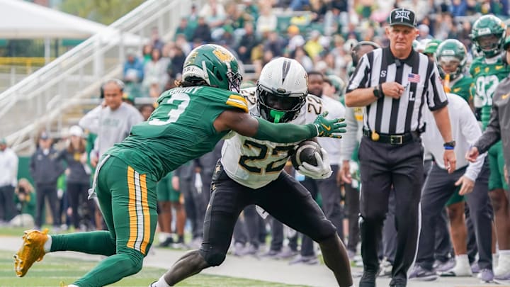Nov 1, 2025; Waco, Texas, USA; UCF Knights running back Myles Montgomery (22) carries the ball as Baylor Bears safety Devyn Bobby (3) defends during the second half at McLane Stadium. Mandatory Credit: Raymond Carlin III-Imagn Images