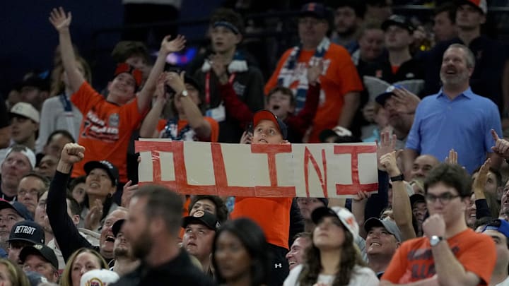 A young fan holds up a Illinois Fighting Illini sign Saturday, April 4, 2026, during a Final Four game against the UConn Huskies at Lucas Oil Stadium in Indianapolis.