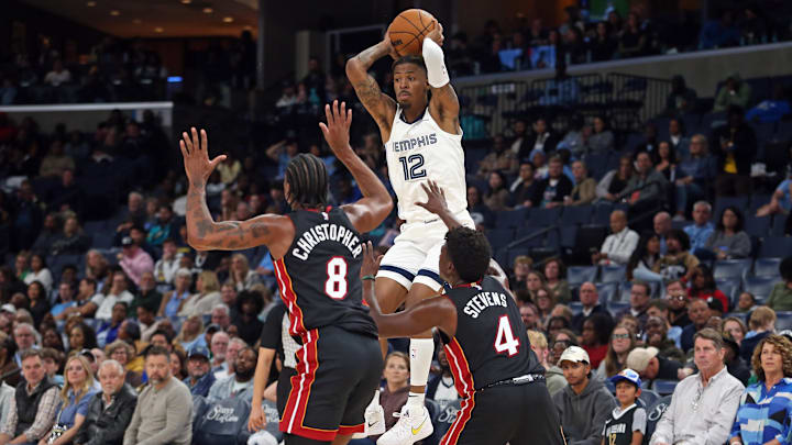  Memphis Grizzlies guard Ja Morant (12) passes the ball over Miami Heat guard Josh Christopher (8) and guard Isaiah Stevens (4) at FedExForum. Mandatory Credit: Petre Thomas-Imagn Images