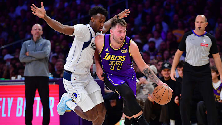 Feb 25, 2025; Los Angeles, California, USA; Los Angeles Lakers guard Luka Doncic (77) dribbles the ball past Dallas Mavericks forward Olivier-Maxence Prosper (8) during the second half at Crypto.com Arena. Mandatory Credit: Gary A. Vasquez-Imagn Images