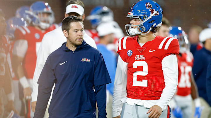 Oct 28, 2023; Oxford, Mississippi, USA; Mississippi Rebels offensive coordinator Charlie Weis Jr. (left) talks with quarterback Jaxson Dart (2) during warm ups prior to the game against the Vanderbilt Commodores at Vaught-Hemingway Stadium. Mandatory Credit: Petre Thomas-Imagn Images