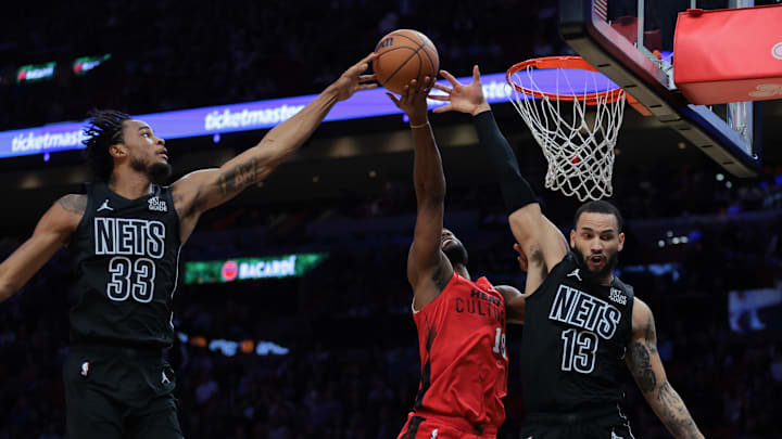 Dec 23, 2024; Miami, Florida, USA; Brooklyn Nets guard Tyrese Martin (13) and Brooklyn Nets center Nic Claxton (33) block a shot against Miami Heat guard Alec Burks (18) during the second quarter at Kaseya Center. Mandatory Credit: Sam Navarro-Imagn Images