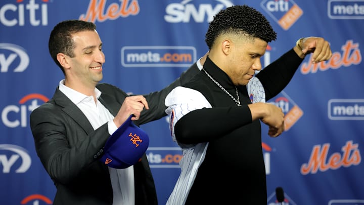 Dec 12, 2024; Flushing, NY, USA; New York Mets general manager David Stearns puts a jersey on new right fielder Juan Soto during Soto's introductory press conference at Citi Field. Mandatory Credit: Brad Penner-Imagn Images