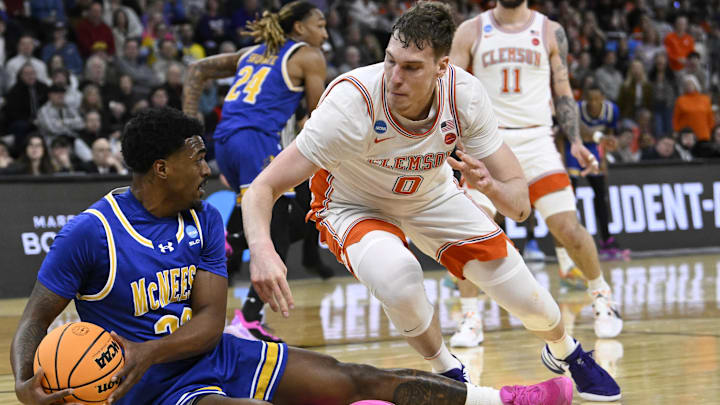 Mar 20, 2025; Providence, RI, USA; McNeese State Cowboys guard Brandon Murray (23) grabs a loose ball against Clemson Tigers center Viktor Lakhin (0) during the first half at Amica Mutual Pavilion. Mandatory Credit: Eric Canha-Imagn Images