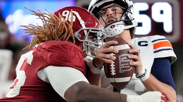 Nov 30, 2024; Tuscaloosa, Alabama, USA; Alabama Crimson Tide defensive lineman Tim Keenan III (96) hits Auburn quarterback Payton Thorne (1) and takes him down for a loss during the Iron Bowl game between Alabama and Auburn at Bryant-Denny Stadium. Alabama defeated Auburn 28-14. Mandatory Credit: Gary Cosby Jr.-Imagn Images