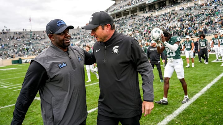 Michigan State's head coach Jonathan Smith, right, meets with UCLA's interim head coach Tim Skipper after the Spartans loss on Saturday, Oct. 11, 2025, at Spartan Stadium in East Lansing.